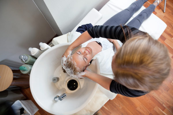 cosmetologist washing the hair of a client