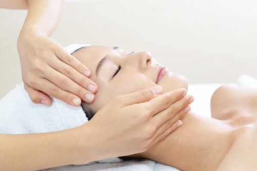 woman getting facial massage from esthetician