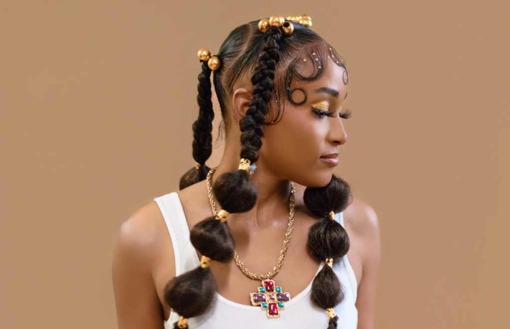 Bubble braids with sculpted baby hair and gold hair beads by Bellus Academy Cosmetology student Zoe Zamarripa, modeled by Kendra Mahoney.